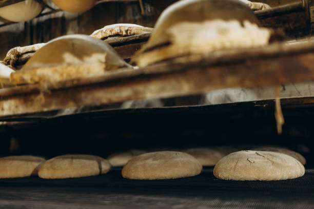 istock The process of baking bread. Unleavened bread. Baker's hand in the frame. Sprinkle bread molds with flour. 2154900390