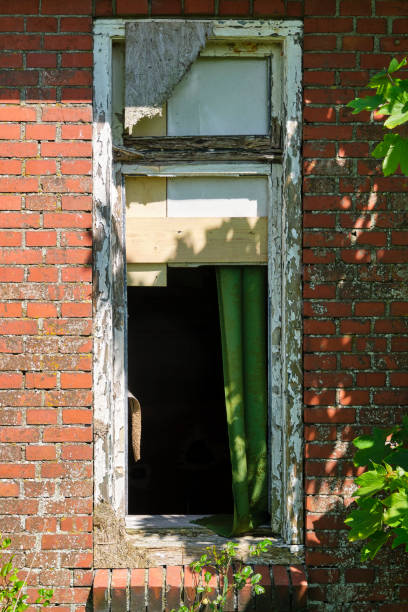 A dilapidated window frame of an abandoned farm