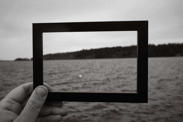 istock Cropped hand holding a photo frame against sea 2154905301