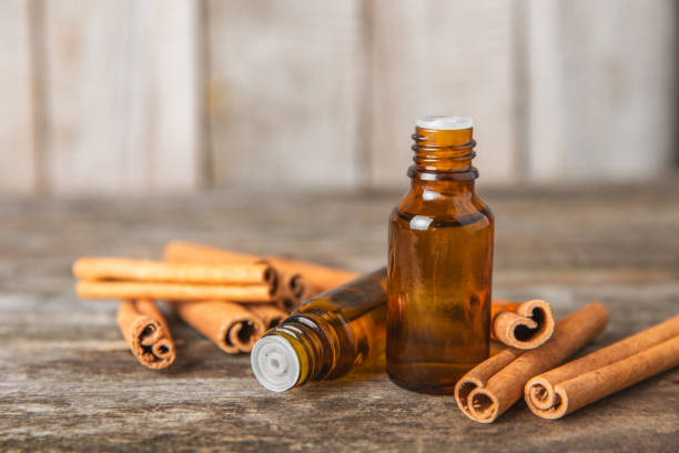 istock Cinnamon aromatic essential oil and cinnamon sticks on  background. Aromatherapy. Organic cosmetic oil. Spa concept. Place for text. Copy space. 2154906476