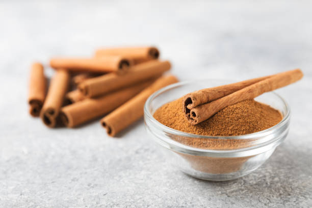 istock Cinnamon powder in a bowl on background. Spicy spice for baking, desserts and drinks. Fragrant ground cinnamon. Cinnamon stick. Place for text. Copy space. 2154907348