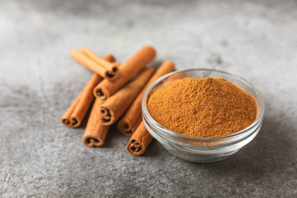 istock Cinnamon powder in a bowl on background. Spicy spice for baking, desserts and drinks. Fragrant ground cinnamon. Cinnamon stick. Place for text. Copy space. 2154907388