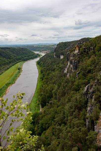 istock A river runs through a lush green valley with a rocky cliff in the background 2154911437