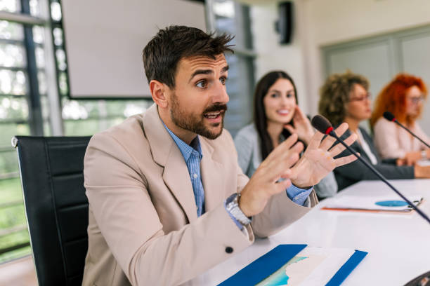 istock Man CEO talking on the microphone on meeting with his colleagues about business plan, future collaboration. 2154911524