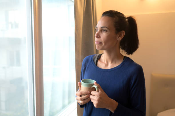 istock relaxed woman looking out the window 2154911808