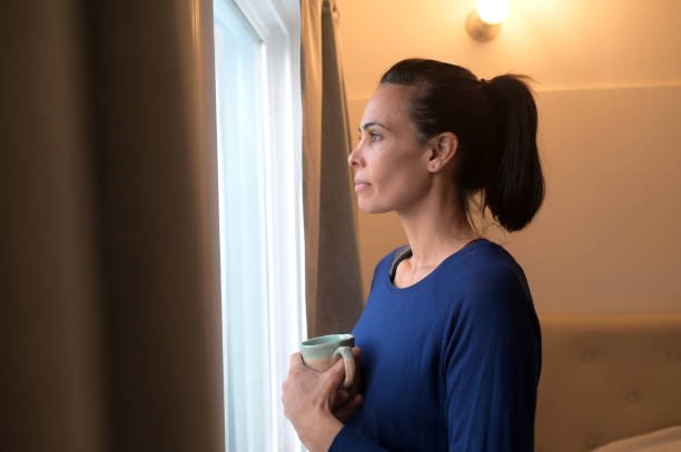 istock relaxed woman looking out the window 2154911812