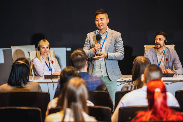 Male Asian CEO having speech on press conference in convention center.