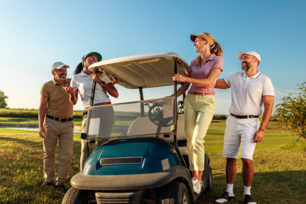 istock Two women standing on the golf cart while two men stand beside them. 2154914583