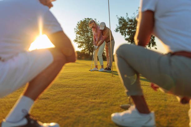 istock Guy golfer demonstrates how to play to a female companion 2154914607