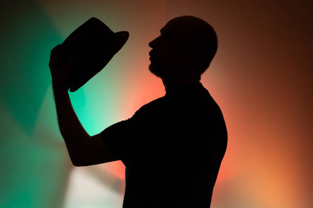 istock Studio portrait of a man holding hat in silhouette. 2154918024