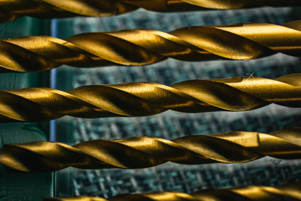 A detailed view of a cluster of metal drills, depicting the intricate design and structure of technical mechanical components commonly used in drills and screw bits. The image showcases the interconnected network of wires in a close-up shot.