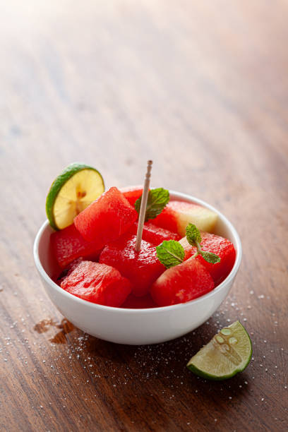 A white ceramic bowl filled decoratively with Organic watermelon (citrullus Lanatus) cubes.