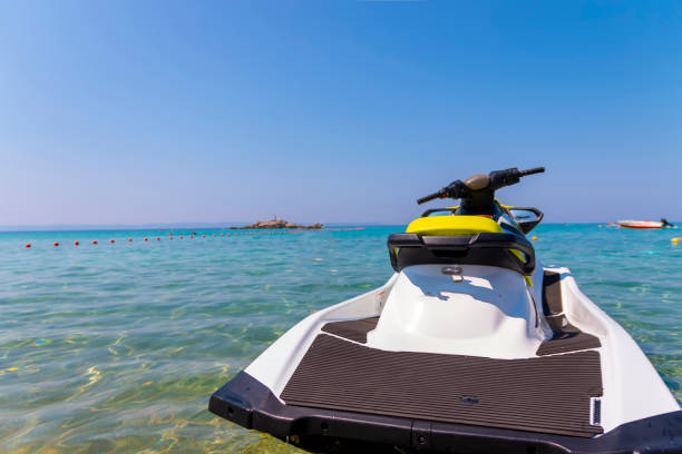 The motorboat, a sleek vessel with a powerful engine, is gracefully navigating the calm, cerulean waters of the expansive sea on a bright, sunny day.