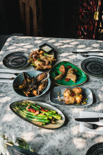 istock Asian Tapas table asparagus mussels dumplings 2154922071
