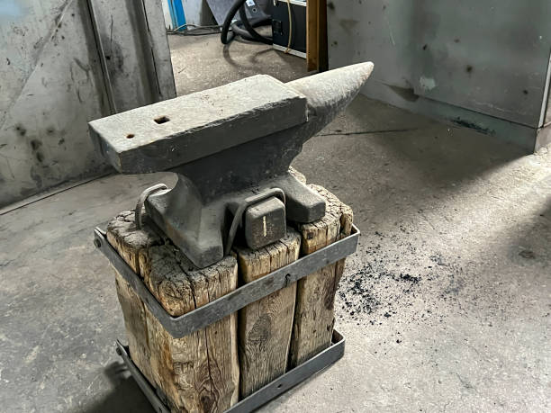 istock An old anvil standing on a base made of wood blocks 2154923541