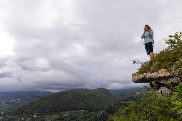 istock Young woman takes photo from cliff 2154923731