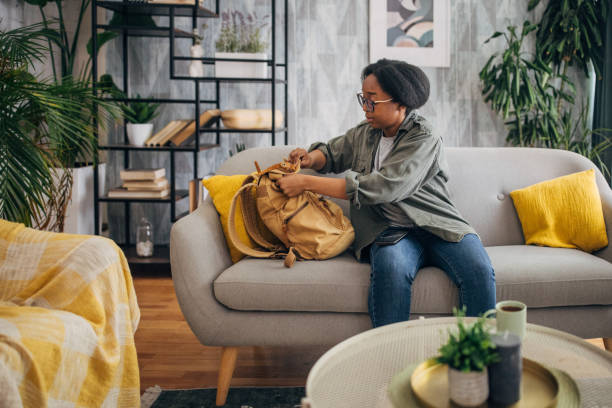 istock Woman sitting on a couch, tying a backpack 2154927421