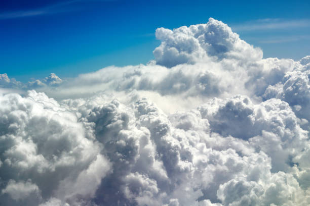 istock Fluffy cumulus clouds spread under a clear blue sky, lit by sunlight 2154929513