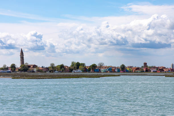 Burano, Italy - View of the colorful houses, the historic water tower and the church Chiesa Parrocchiale di San Martino Vescovo with the leaning steeple on the island of Burano in the Venice lagoon