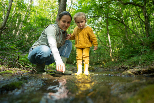 Sustainability and Eco mind. Family participating in riverbed cleanup in the forest in spring.