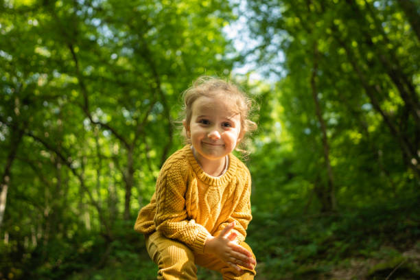 Sustainability and Eco mind. Happy little girl hiking in the forest in spring.