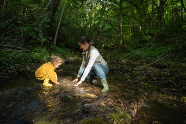 istock World Environment Day. Family Cleans River in Forest. 2154933741