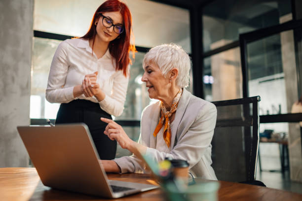 istock Senior businesswoman discussing paperwork on tablet with her worker. 2154933874