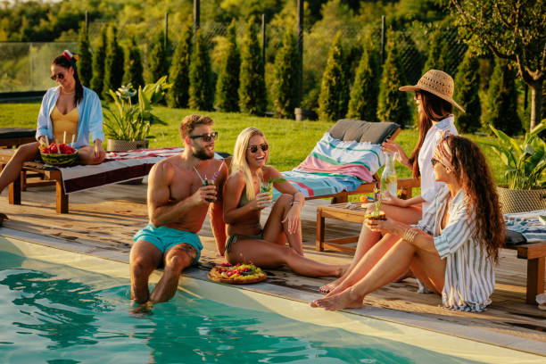 istock Friends chilling by the pool and drinking cocktails 2154934051