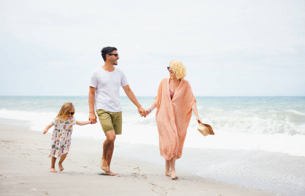 istock Happy Family Enjoying a Beach Walk Together 2154941473