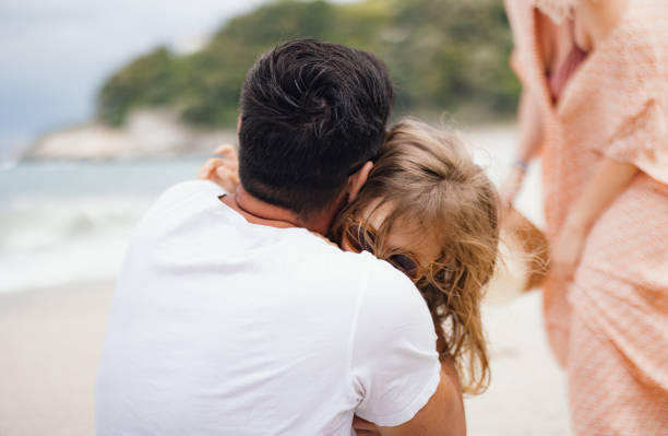 istock Father Embracing Child on a Sandy Beach 2154941481
