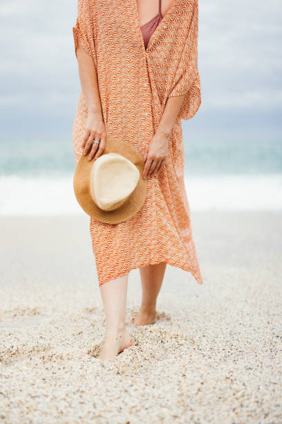 istock Woman Relaxing on a Tranquil Beach Holding a Sun Hat 2154941551