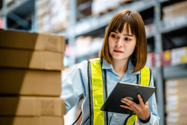 istock Women warehouse worker using digital tablets to check the stock inventory on shelves in large warehouses, a Smart warehouse management system, supply chain and logistic network technology concept 2154942271