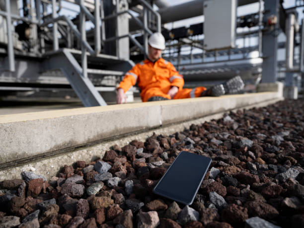 Worker fell, phone on ground, industrial site.