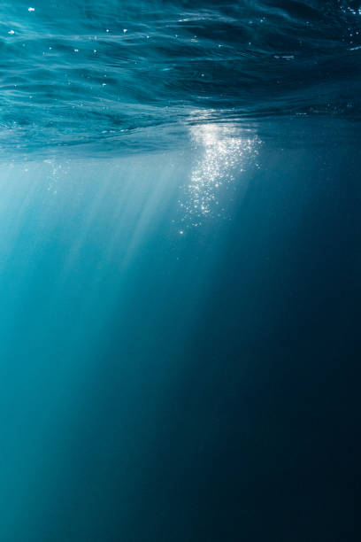 istock Sun rays of lights underwater in to blue clear ocean and bubbles 2154945240