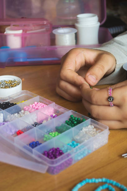 istock hands make a bracelet of beads 2154946705