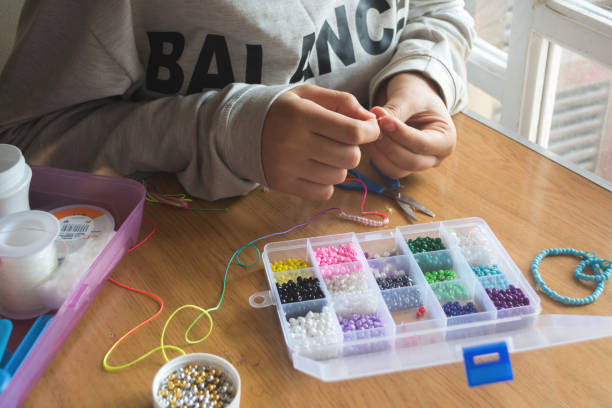 istock hands make a bracelet of beads 2154946706