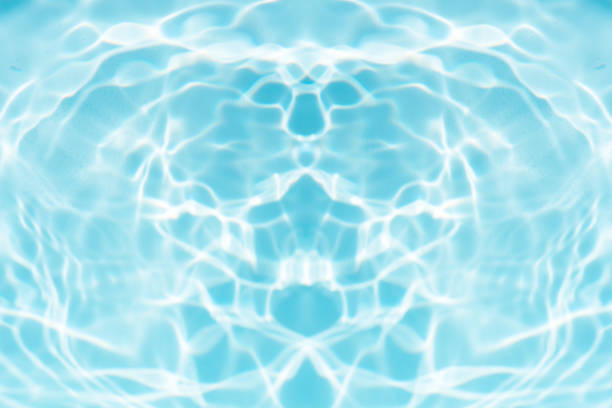 Blue water with ripples on the surface. Defocus blurred transparent blue colored clear calm water surface texture with splashes and bubbles. Water waves with shining pattern texture background.