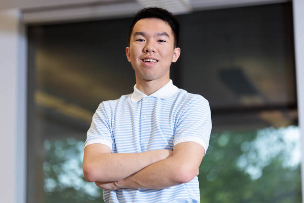 istock College student standing with crossed arms in a classroom 2154950470