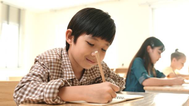 istock Close up of smart asian student writing or taking a note during test. Pedagogy. 2154950993