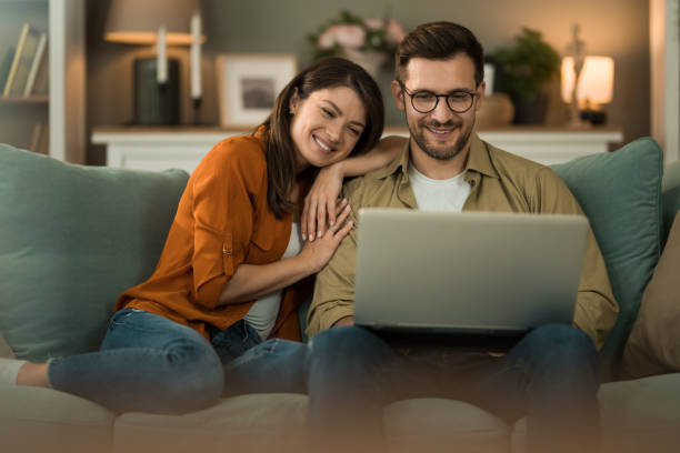 istock Couple browsing the net on laptop at home. 2154951296
