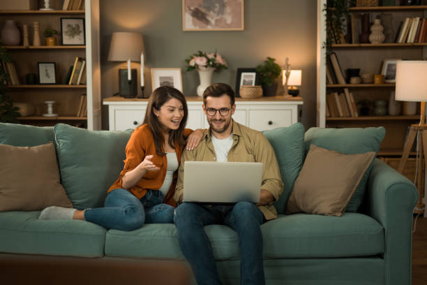 istock Couple browsing the net on laptop at home. 2154951341