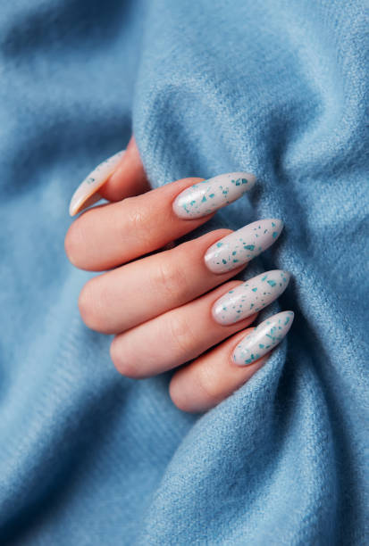 istock Female hands with blue nail design on blue textile background. 2154952226
