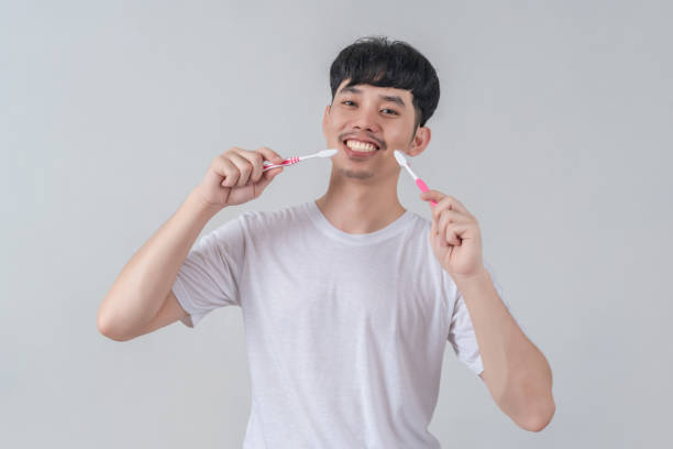 istock Handsome young man holding several colorful toothbrushes. 2154952835
