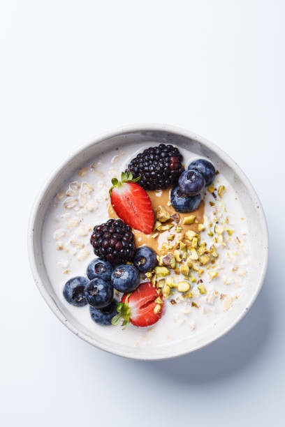 istock Oatmeal with fresh berries and nuts, white background. Healthy breakfast concept. 2154956383