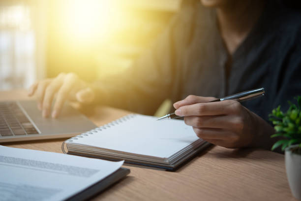 istock Female hand holding a pen to write goals or take diary notes on the desk 2154957797