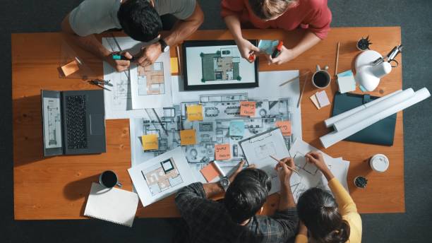 istock Top down view of engineer handed document while looking at blueprint. Symposium. 2154957900