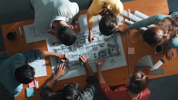 istock Top down view of engineer team writing at blueprint at meeting table. Symposium. 2154959303