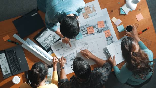 istock Top view of engineer team holding blueprint and standing at table. Symposium. 2154959658