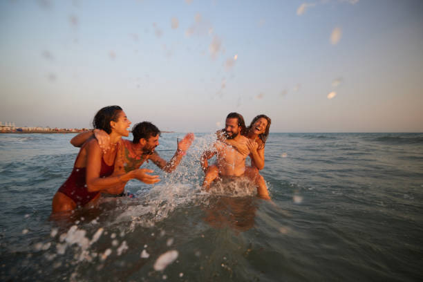 istock Young cheerful couples having fun during summer vacation in sea. 2154960490