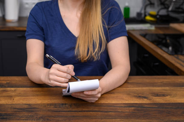 istock A woman makes a shopping list in a paper notebook 2154960655